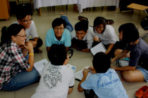 An image of a group of students in a circle working on a task together