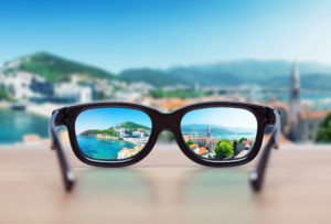 An image of a blurred landscape brought into focus by a pair of glasses